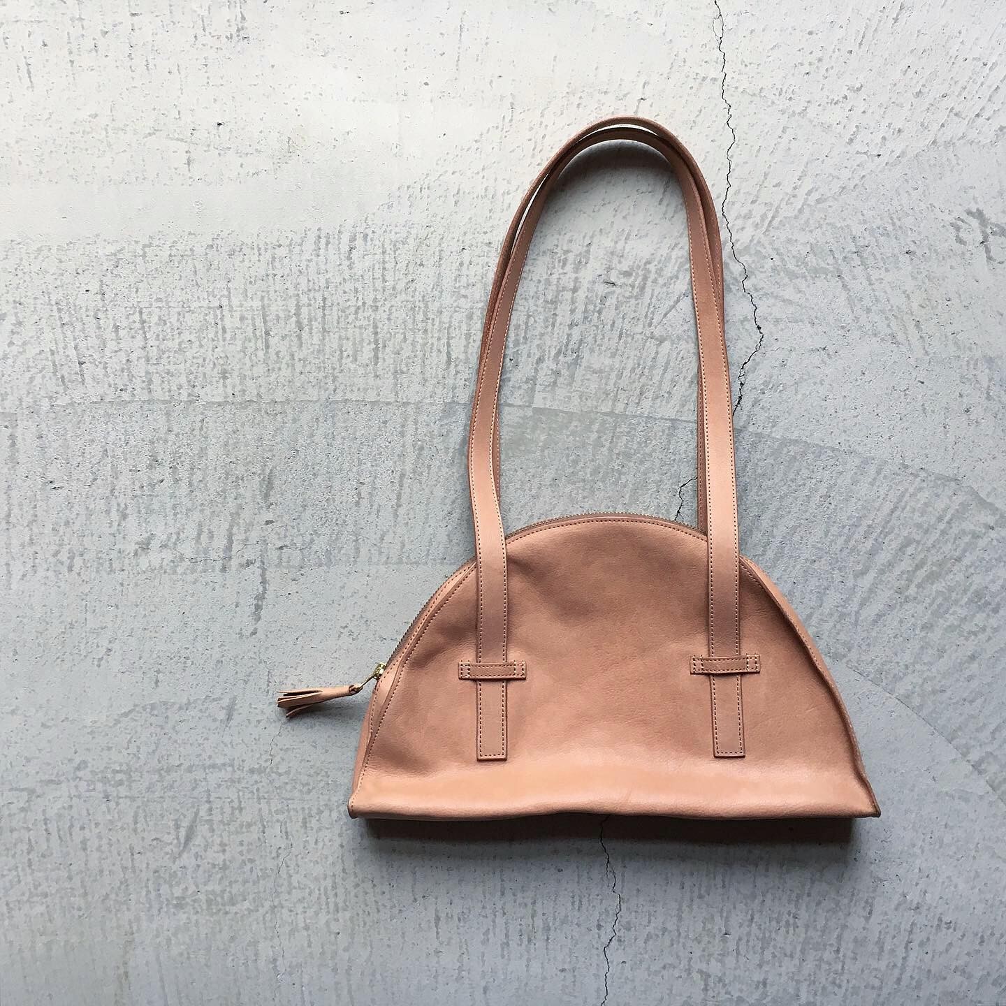 ＊新しいTASSEL BOSTON BAGのナチュラルカラー真っ新なカラーでふわふわの触り心地500mlのペットボトルもすっきり収まるサイズです。肩にかけた状態でスムーズにファスナーの開閉が出来るよう緻密に計算しデザインに落とし込みました。シンプルなものほど、奥が深く素材の良さや技術が輝きます。詳しくはWEB SHOPをご覧下さい。